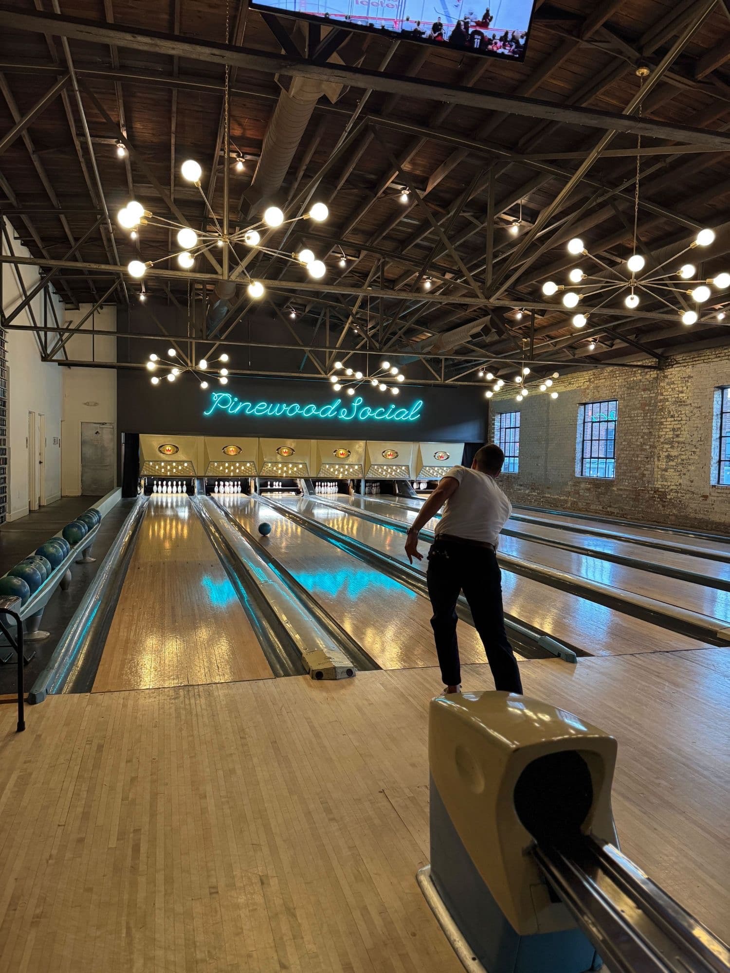 A guest bowling at Pinewood Social during a Chord community event