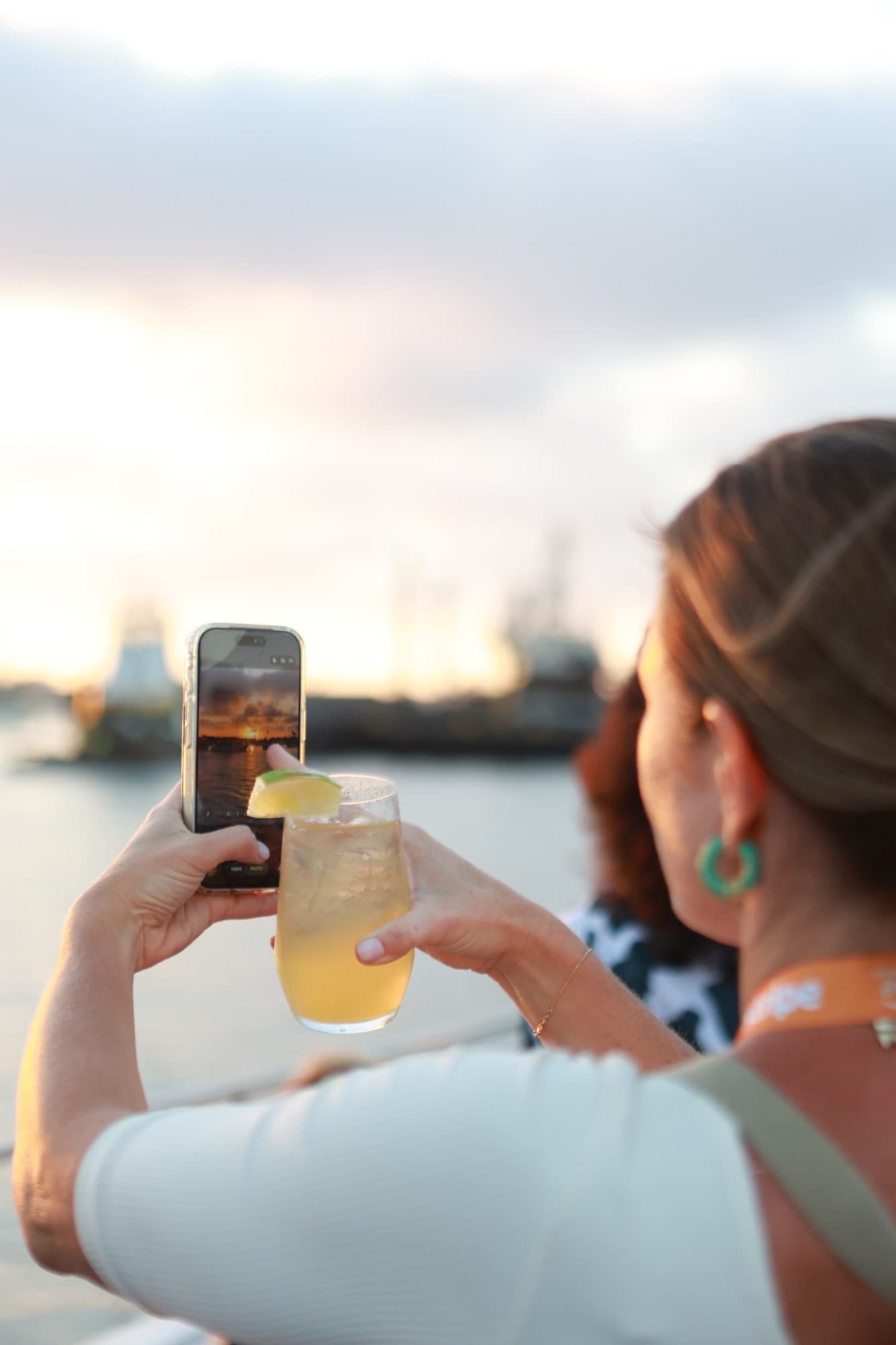 A guest photographing the sunset over the harbor at a Chord community event